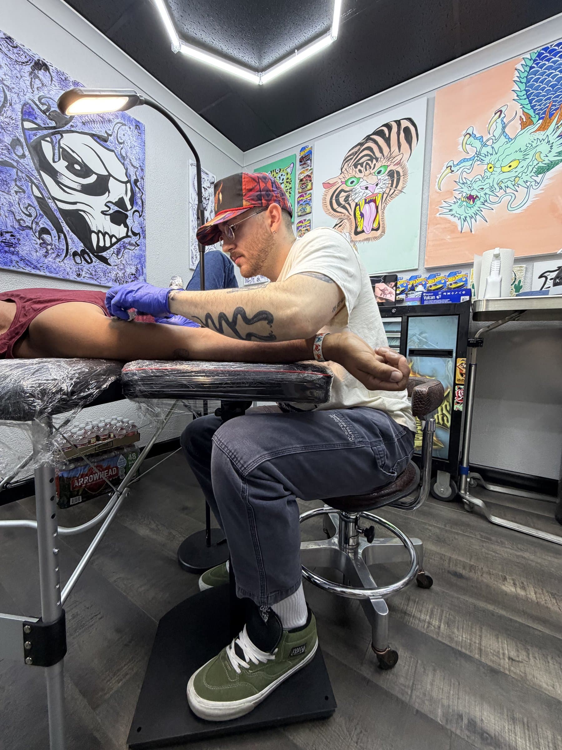 Studio interior — Will at work surrounded by colorful flash sheet originals on the walls